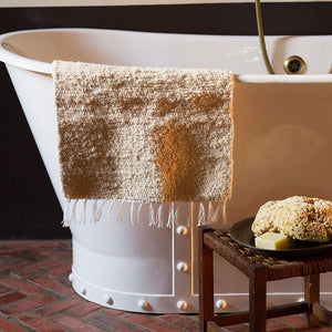 Hand Wove Bath Mat Draped Over Bath Tub