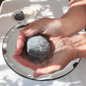 Person lathering JDBotanics oily hair shampoo bar in hands showing rich botanical lather